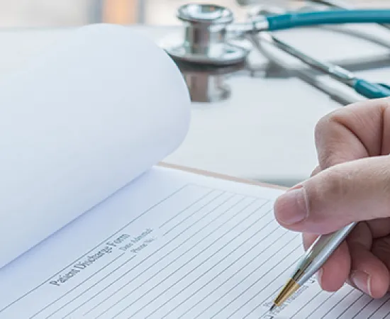 Healthcare worker writing on chart.